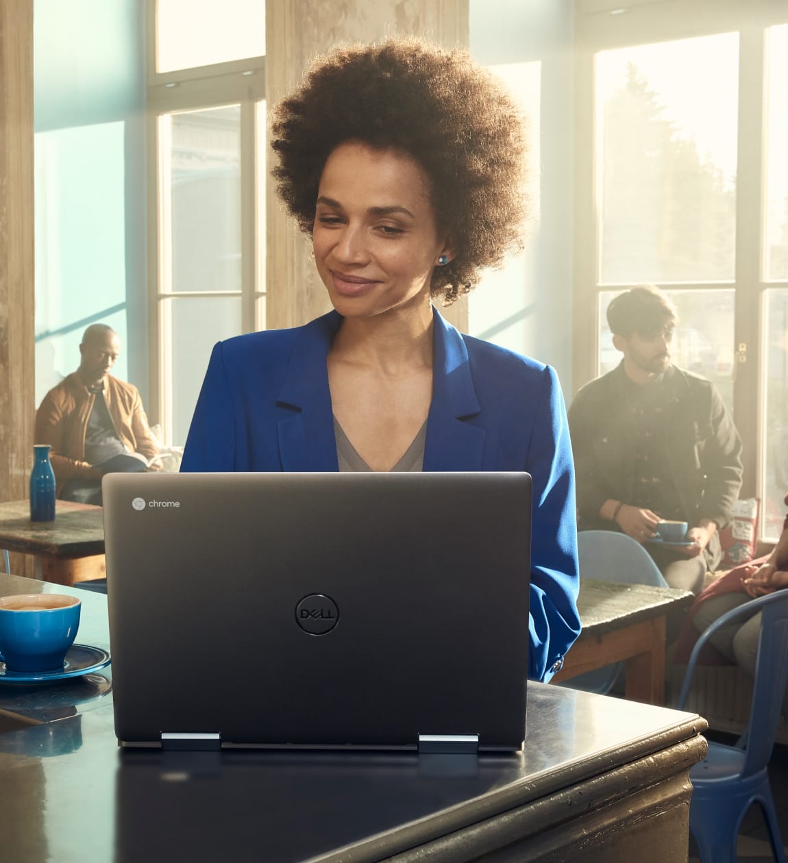 En un café, una madre configura las reglas de uso de dispositivos para sus hijos desde su Chromebook.